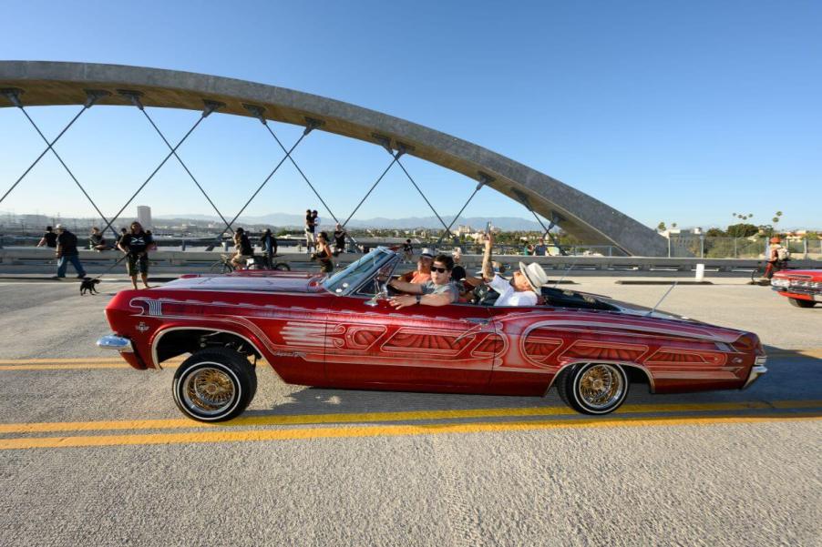 Kevin de León in a 1960s-era Chevy Impala custom lowrider model crossing 6th Street Bridge in Los Angeles