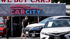 Three used vehicles visible in a car lot.