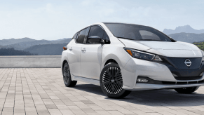 A 2024 Nissan Leaf all-electric hatchback model parked on a brick tile plaza in the mountains