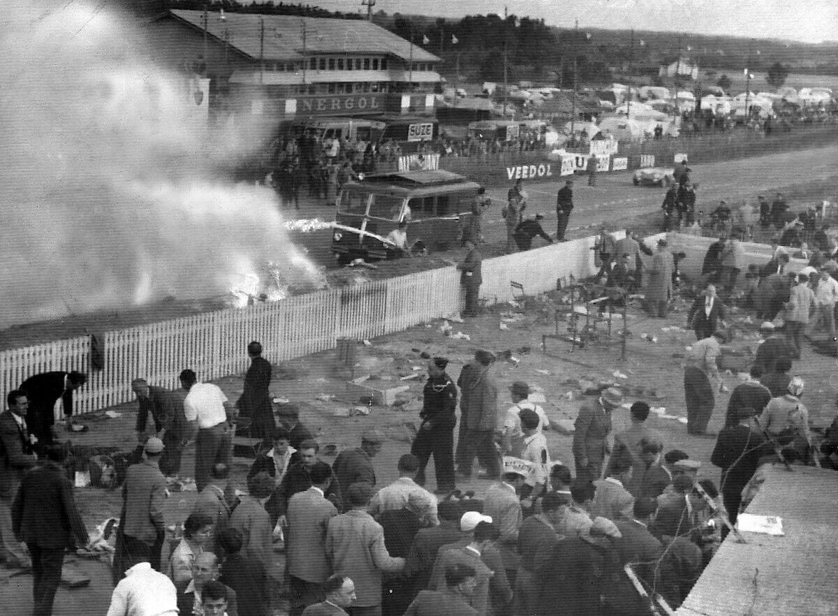 A side view of firefighters and motorsport staff battling the fire at the 1955 Le Mans disaster.