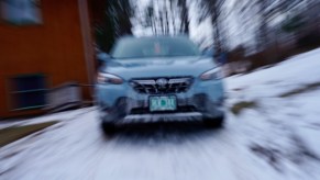 The grille of a cool Khaki colored Subaru crosstek car, the background blurry.