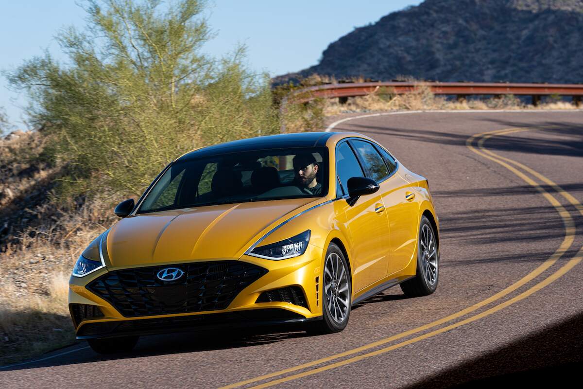 A yellow 2020 Hyundai Sonata travels on a curvy mountain road