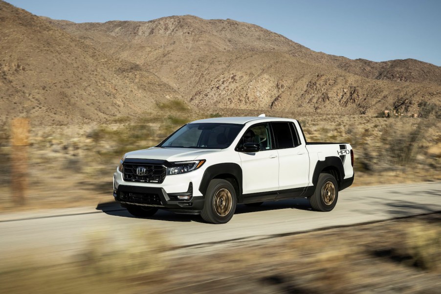 A white 2023 Honda Ridgeline driving in the desert. Honda Ridgeline sales should be higher than what they are.