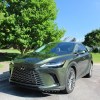 The 2023 Lexus RX 350h parked near green trees