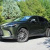 The 2023 Lexus RX 350h parked near foliage