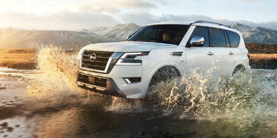 A white 2023 Nissan Armada full-size SUV is driving off-road.