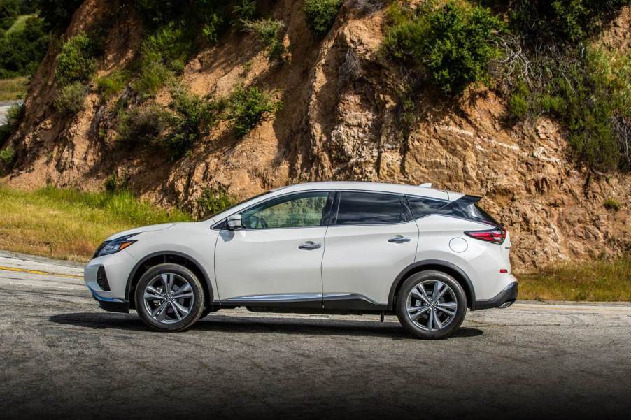 A white Nissan Murano driving down the road.