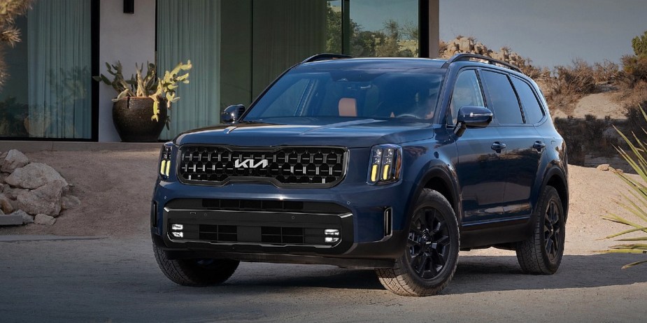 A blue 2024 Kia Telluride midsize three-row SUV is parked. 