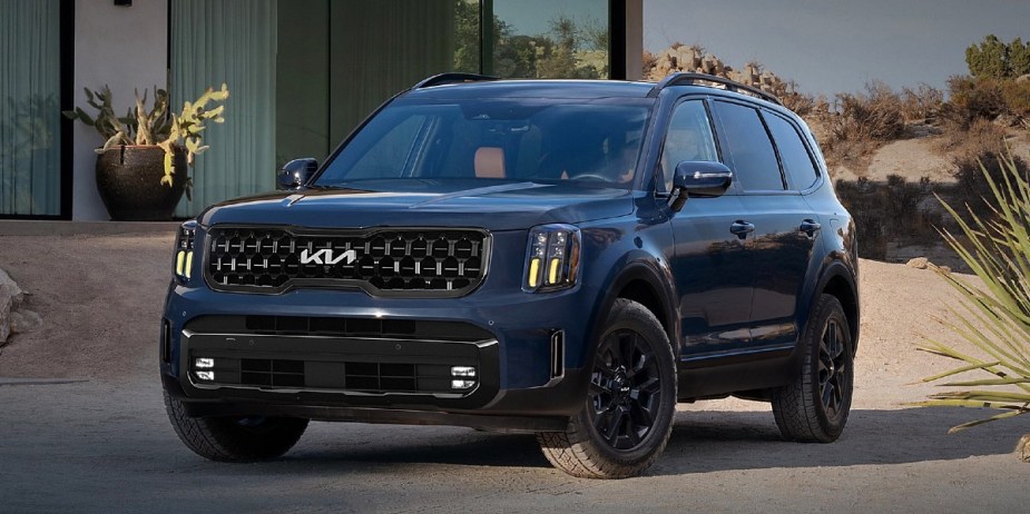 A blue 2024 Kia Telluride midsize three-row SUV is parked. 