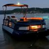 A 2024 Sea-Doo Switch Cruise Limited shows off its orange lighting at night.