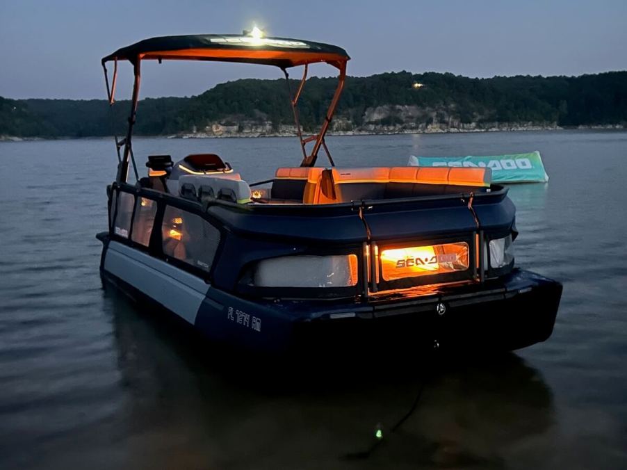 A 2024 Sea-Doo Switch Cruise Limited shows off its orange lighting at night.