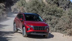 A red 2024 Hyundai Tucson driving down a mountain path. Hyundai manufacturing should impact growth for the Tucson