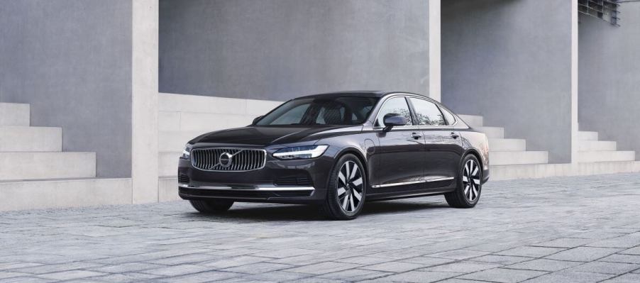 A 2024 Volvo S90 Recharge executive sedan model parked on gray tiles near rows of stone stairs