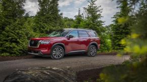 A red Nissan Pathfinder in the woods.