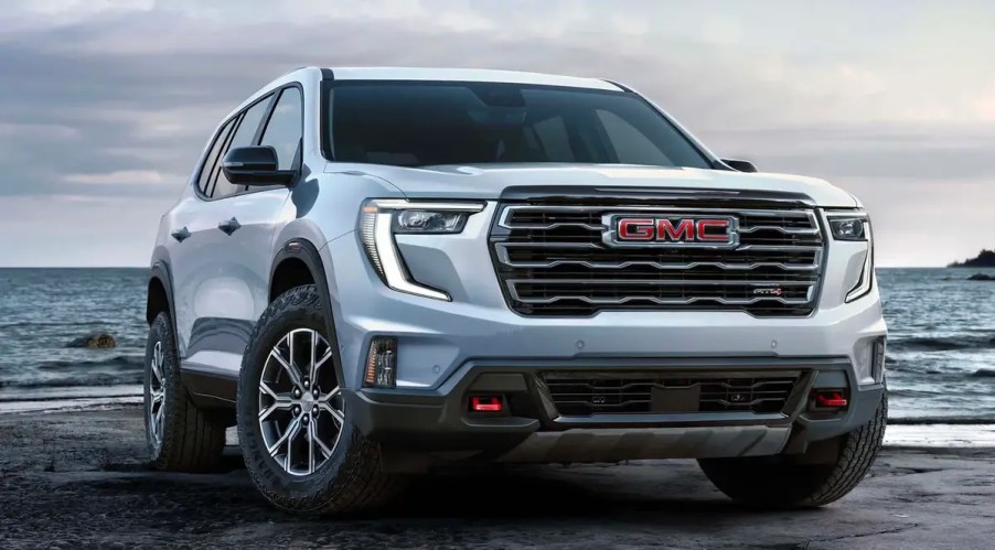 White 2024 GMC Acadia SUV on the sand by water