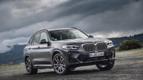 A black 2023 BMW X3 parked on a stormy day. The X3 is one of a few affordable luxury compact SUV options.