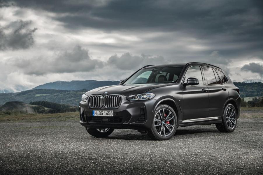 A BMW X3 xDrive30d compact luxury SUV model parked on a gravel plain under darkening clouds