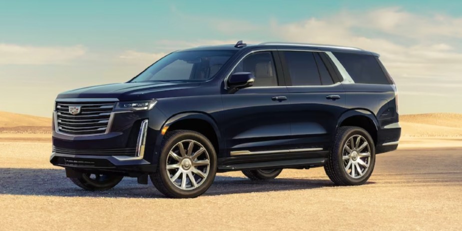 A black Cadillac Escalade full-size luxury SUV is parked outdoors.