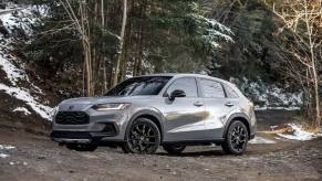 The 2024 Honda HR-V in silver in the slightly snowy woods. The cheapest Honda SUV has some good features