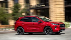 A red pre-production 2023 Ford Escape driving on a city road. Ford Escape sales numbers are actually pretty high.