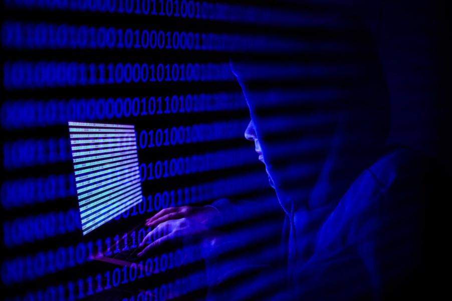 Cyber hackers in dark room with computers