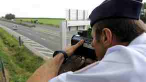 Police officer hides on a bridge during a speed trap.