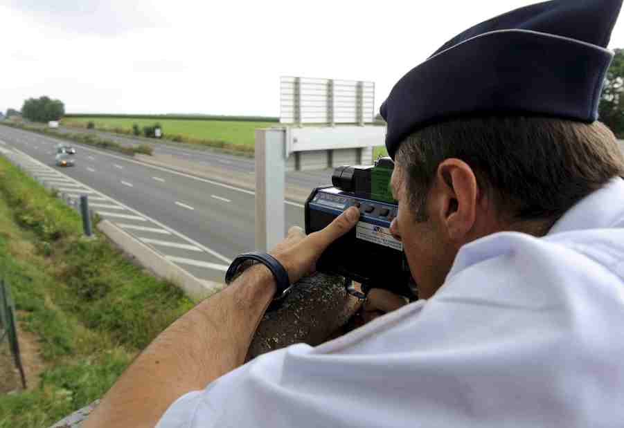 Police officer hides on a bridge during a speed trap.