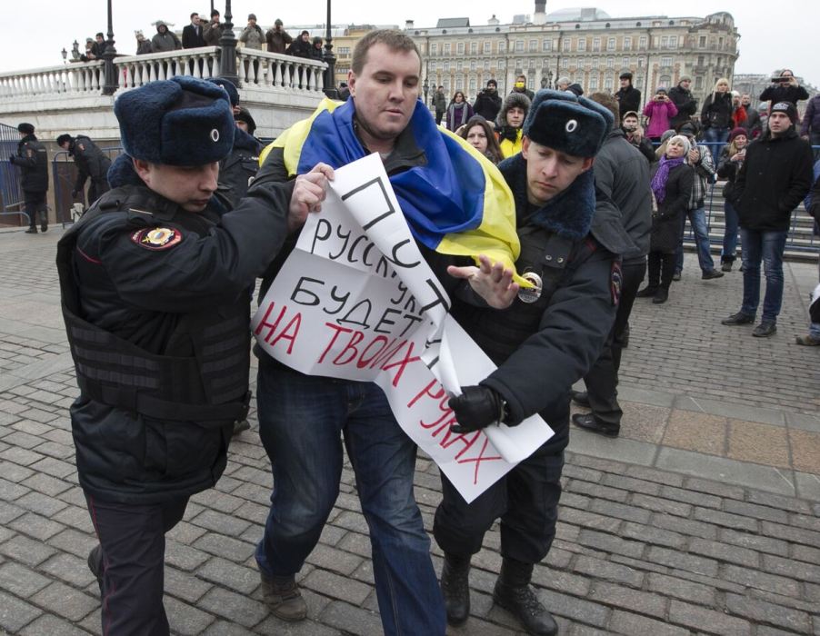 Man being arrested with sign