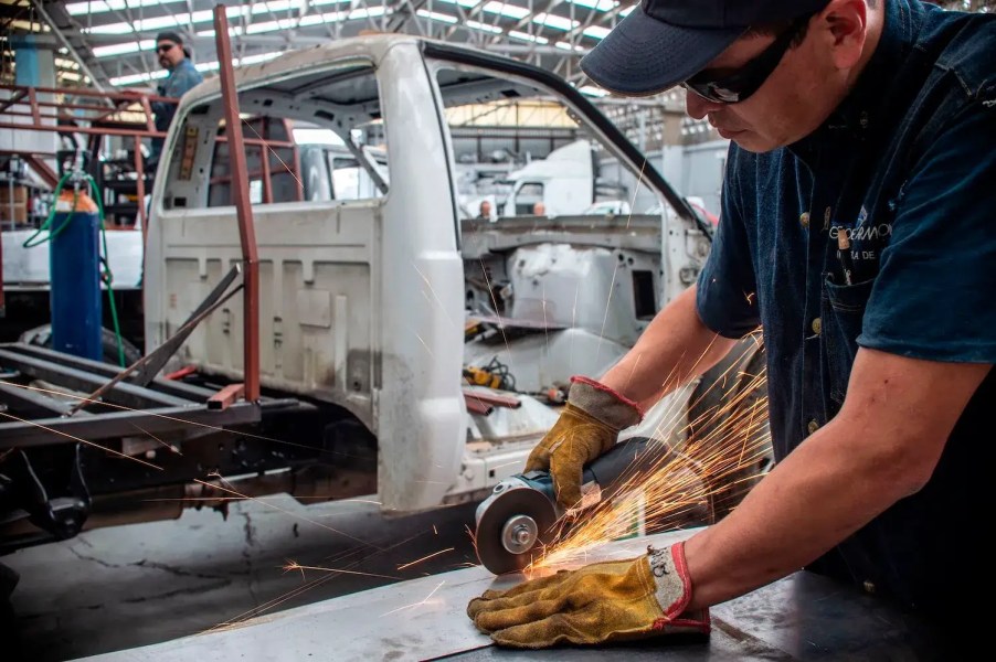 A Mexican factory worker assembles a heavy-duty pickup truck.