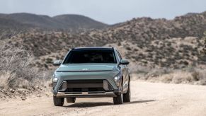 A green 2024 Hyundai Konda on a desert road. The Hyundai Kona and Venue are closely linked