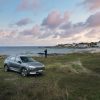 A gray Hyundai Nexo parked along the coastline at the beach. The Hyundai Nexo's hydrogen fuel cell makes it a unique model.