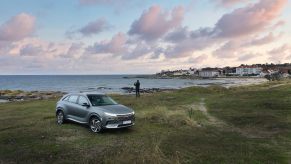 A gray Hyundai Nexo parked along the coastline at the beach. The Hyundai Nexo's hydrogen fuel cell makes it a unique model.