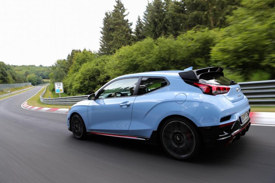 A light blue Hyundai Veloster driving down the road.