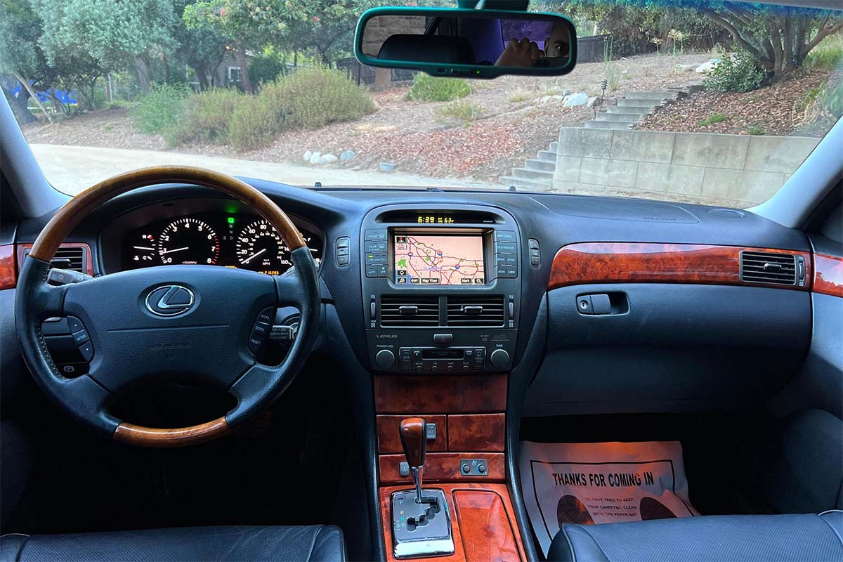 Interior of a 2004 Lexus LS430 affordable luxury car displaying black leather interior and infotainment system with GPS navigation