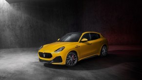 A yellow Maserati Grecale Trofeo on display against a gray backdrop. The Maserati Grecale's price is a huge barrier to entry.