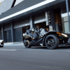 A pair of Polaris Slingshot three-wheeler models racing through a downtown city section and deserted street