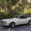 1968 Chevrolet Camaro in parking lot next to trees