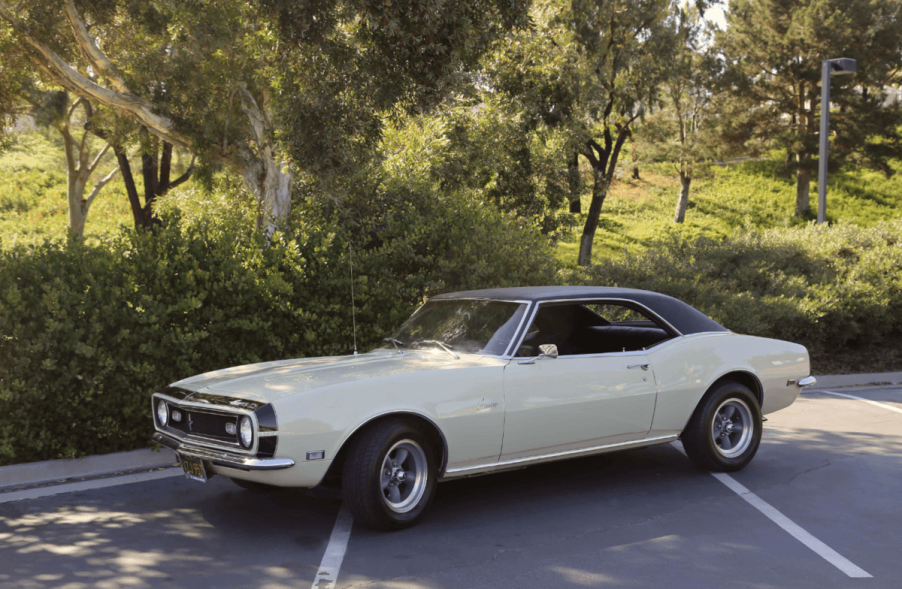 1968 Chevrolet Camaro in parking lot next to trees