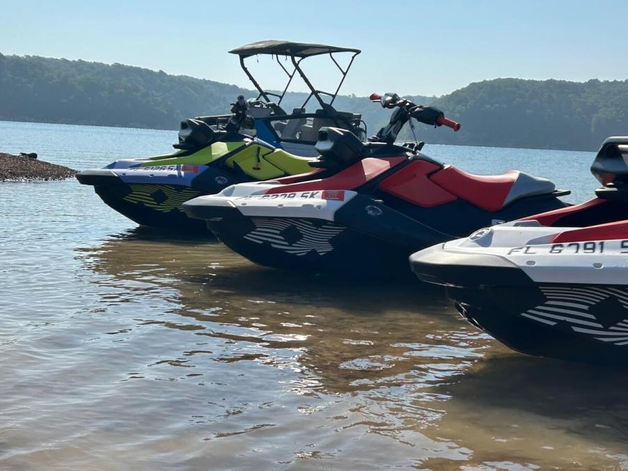 Jet skis and PWCs sit by the waters edge, waiting for a day of jet skiing.