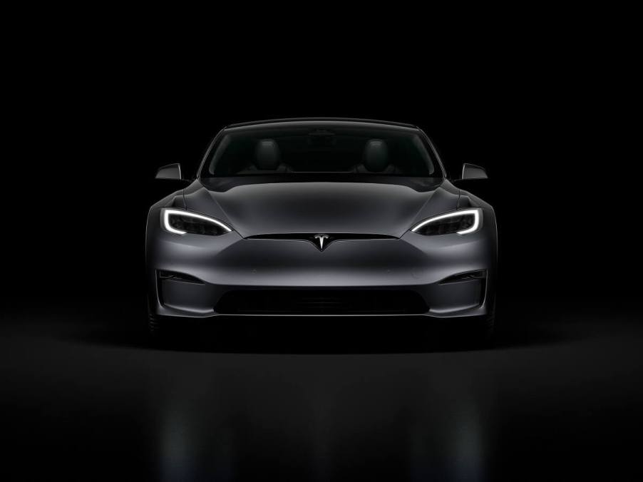 A gray Tesla Model S sits in the dark.