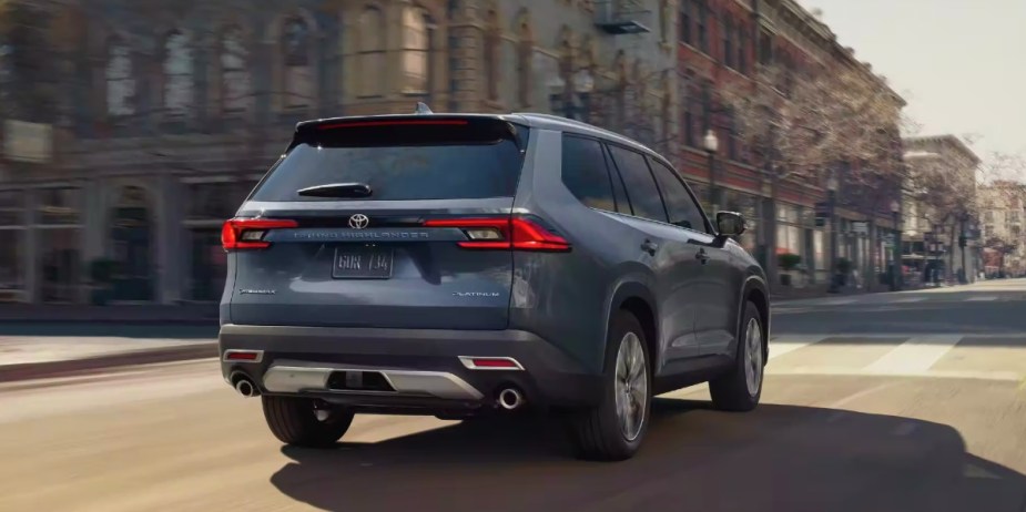 A blue fully loaded 2024 Toyota Grand Highlander Hybrid MAX is driving on the road. 