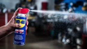 WD-40 spray lubricant with hand spraying out the product