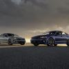 A pair of 2024 Kia K5 midsize sedan models parked on an asphalt lot and framed by a setting sun