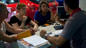 A car salesperson talks to his customers