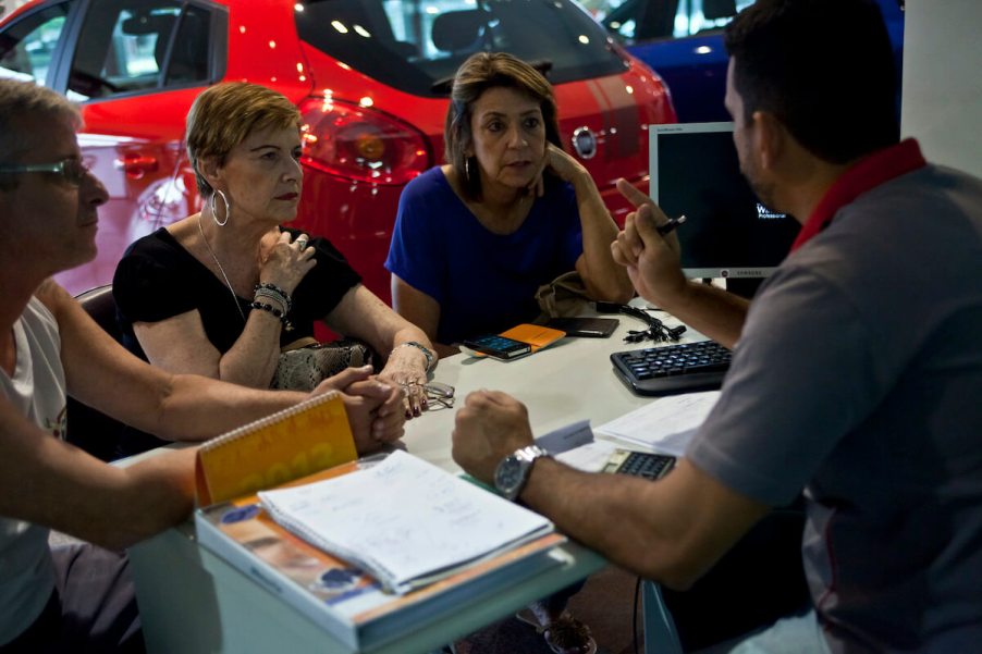 A car salesperson talks to his customers