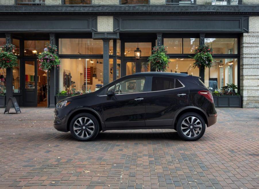 A side profile shot of a 2022 Buick Encore subcompact SUV model parked on a cobblestone walkway