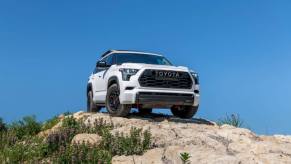 A 2024 Toyota Sequoia TRD-Pro midsize SUV model parked on a rocky hill covered in purple flowers