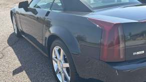 Closeup of the tail light in a black Cadillac XLR luxury sportscar coupe.