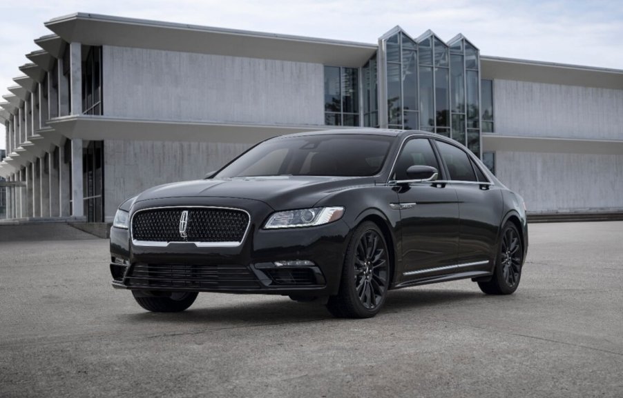 A black 2020 Lincoln Continental Black Label luxury sedan with AWD parks next to a large building.