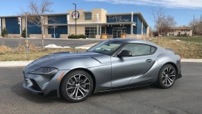 The front corner view of the 2021 Toyota Supra 2.0 next to a Curling Center